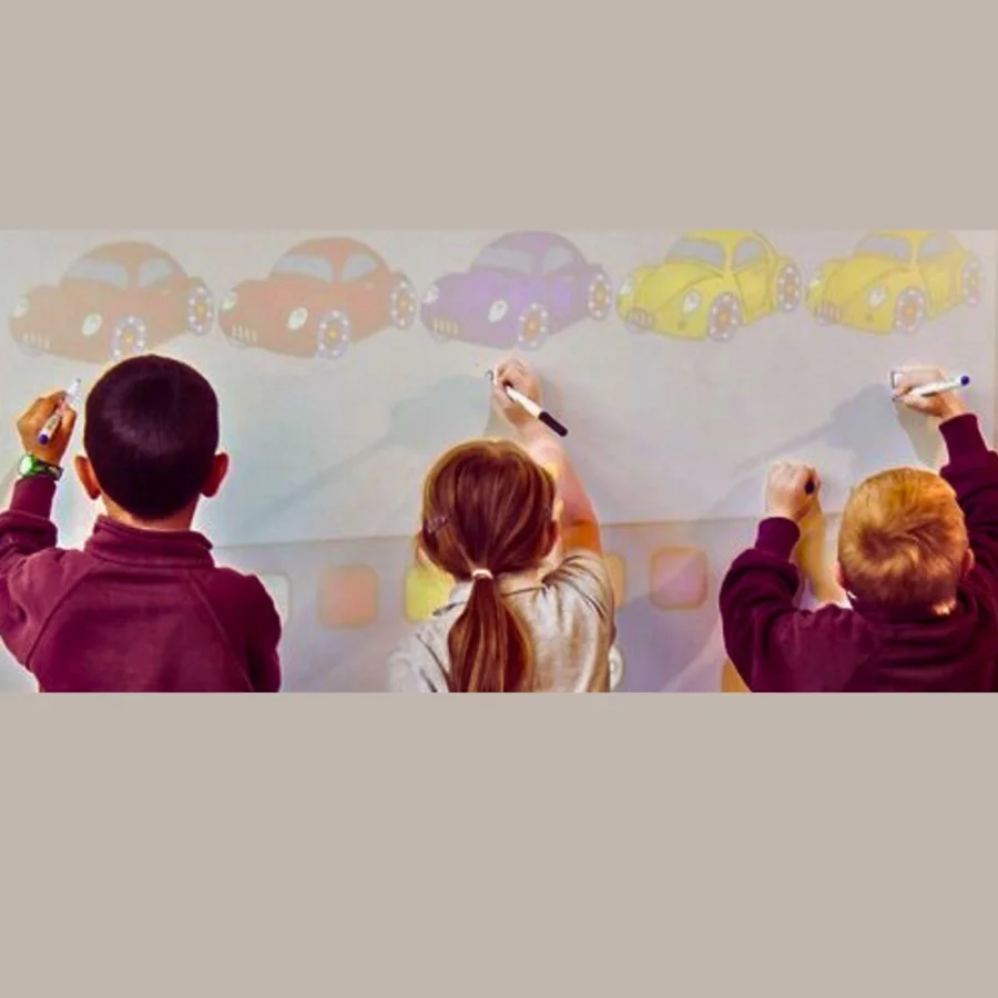 Kids using classroom wall with interactive projector screen paint
