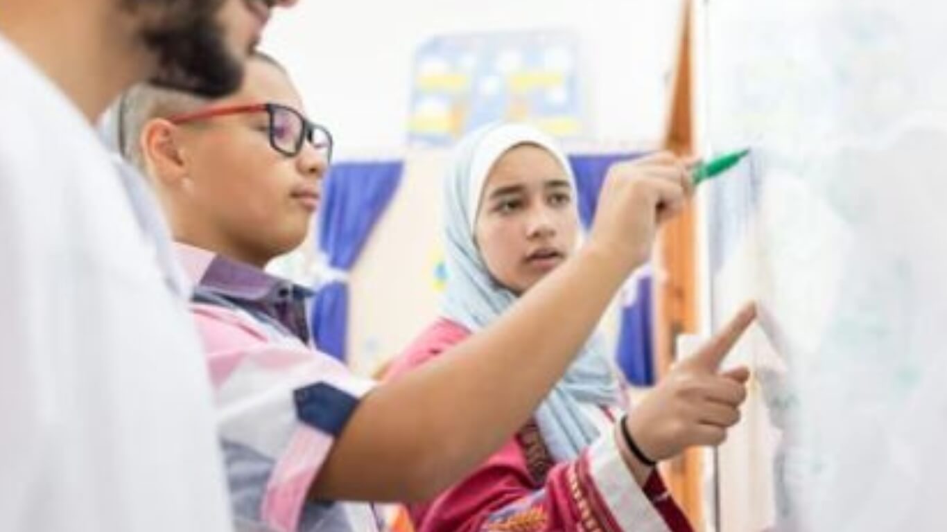 Student writing on whiteboard UAE schools